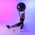 Person exercising with an exercise ball with hiveact reaction lights