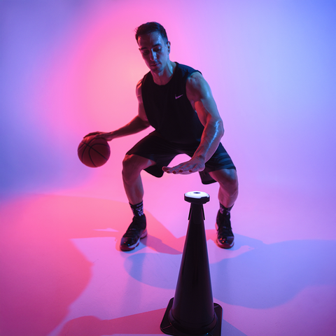 Person playing basketball drills with reaction lights and with the cone adaptors.