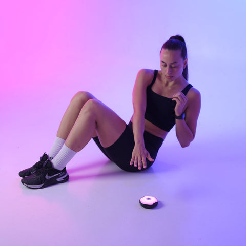 Woman in athletic wear is sitting on the floor with the reaction lights